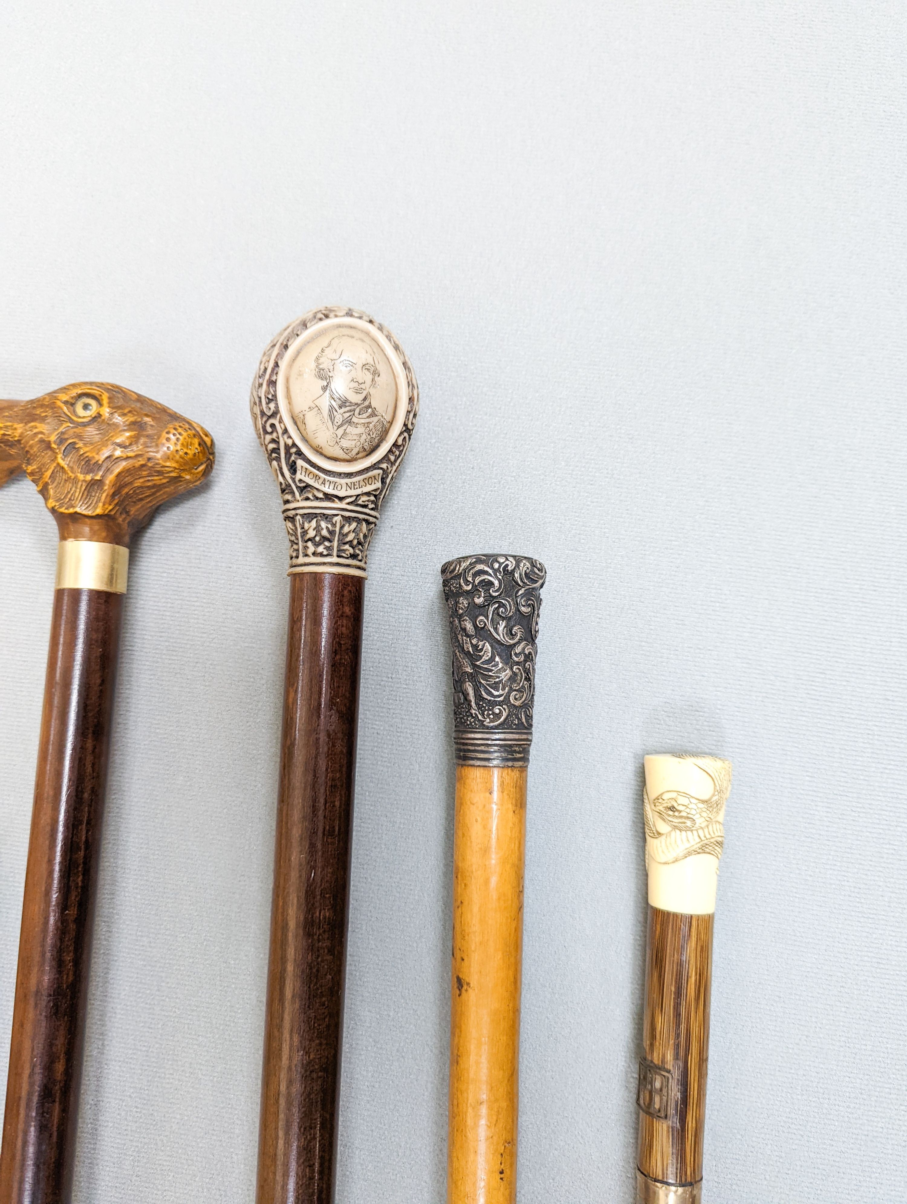 A gold mounted ivory handled walking cane carved with a coiled snake, a silver mounted Mallacca cane, an ivory handled ebonised stick and six others. (9)